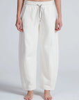 White ASKK Cancun Sweatpant with relaxed barrel fit, shown barefoot against a plain light background.