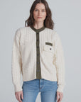 ASKK Greenwich Cardigan in cream cable knit, styled with a green shirt and blue jeans for a relaxed, cozy look.