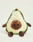 The Avocado Warmies by Faire is a microwavable plush toy shaped like a smiling avocado, featuring a light green center, dark green edge, brown pit, and cozy lavender scent. It sits upright against a plain background.