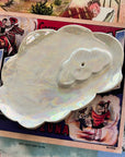 The Cloud Incense Burner by Faire features a shiny, iridescent design shaped like overlapping clouds and is displayed on a vintage postcard with colorful illustrations and text.