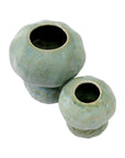 The Import Collection’s Connolly Vases—two round, handcrafted ceramics with wide openings and a muted green glaze—bring modern organic style to any space. Shown side by side on a white background.