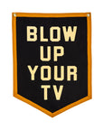 The Blow Up Your TV Pennant 18x24 by Oxford Pennant features bold cream letters on black, golden yellow trim, and “BLOW UP YOUR TV” text inspired by the Spanish Pipedream. Includes two metal grommets for easy hanging.