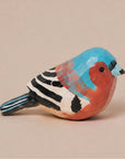 Hand-painted blue carved wood bird figurine by Faire, vibrant accent for rustic home décor.
