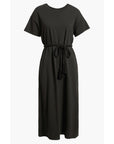 The Boxy Tee Dress by The Great Inc. is a black, short-sleeve, crew neck midi dress with a braided tassel waist tie, crafted from 100% cotton in a T-shirt silhouette and shown against a white background.