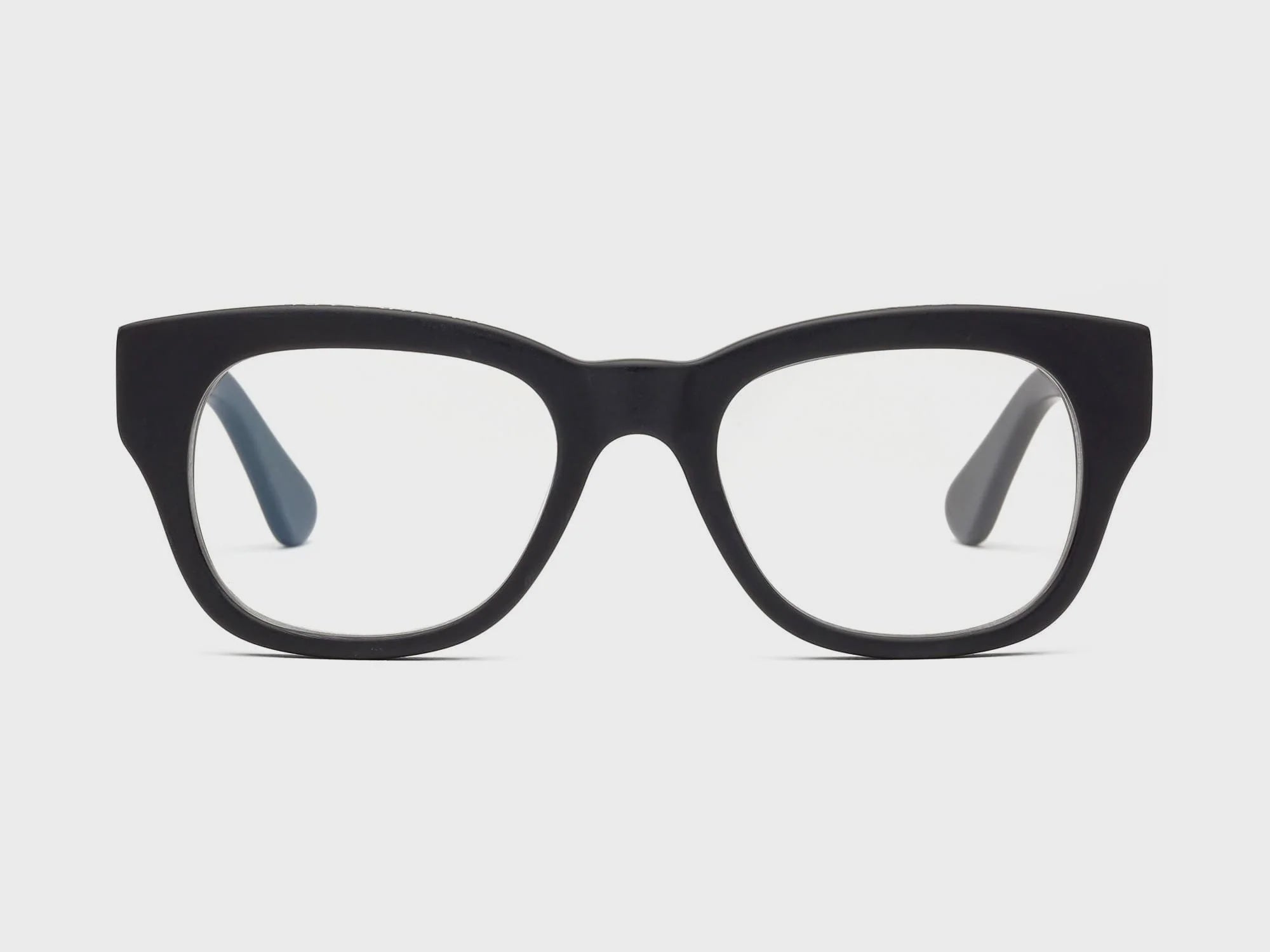 A pair of Caddis Milkos Matte Black glasses against a white background, with square oversized lenses and a pronounced bridge.