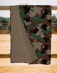 The Faire Cheyenne Camo Quilt features a green, brown, tan, and black camo pattern on one side and a small brown floral print on the other—ideal for quilt lovers in Fort Worth, Texas.