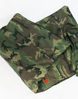 Two Hedgehouse Throwbed pillows with cotton removable covers in a camouflage pattern rest on a white surface, one slightly overlapping the other. A fabric tie is attached to one; both are machine washable for easy care.