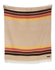 The Sackcloth & Ashes/Desert Camp blanket by Sackcloth & Ashes showcases beige fabric with red, brown, and yellow stripes near the edges, finished with fringe on both ends and displayed flat against a white background.