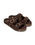 The Beek CEDAR is a dark brown suede slide sandal with two adjustable straps, large gold buckles, gold stud accents, a cork sole, and a memory foam footbed for extra comfort.