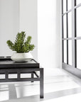 The AllState Floral And Craft Senecio in Planter sits on a modern black table near large grid-style windows in a bright, minimalist room.