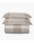 Two beige and white buffalo check pillows rest atop the matching Chalmers Quilt Nat Q by Amity Home, all set against a plain white background.