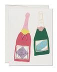 A Faire greeting card featuring colorful illustrations of two champagne bottles with text labels, one pink and one green, inspired by the vibrant nightlife of Scottsdale, Arizona. The text on the pink bottle reads "Let's Celebrate.