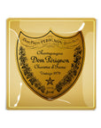 The Dom Perignon Brut Glass Tray by Faire is a gold handcrafted glass tray featuring the champagne label with black text “Champagne Dom Pérignon Charme d’Irene Vintage 1979” and vine details on the edges.