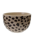 The Creative Co-op Bowl with Animal Print is a round beige stoneware bowl with irregular black leopard-like spots, perfect for serving small dishes. Shown against a plain white background.