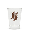 Brown cowboy boots with spurs on clear glass, Fishes Eddy Cowboy Boots Shot Glass, perfect for barware collections.