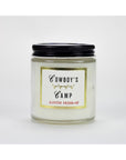 The Faire Austin Press Travel Candle comes in a clear glass jar with a black screw-on lid and botanical waxes. The label says "Cowboy's Camp" over "Austin Press SF," framed by gold, set against a white background.