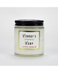 The Faire Austin Press Travel Candle comes in a clear glass jar with a black screw-on lid and botanical waxes. The label says "Cowboy's Camp" over "Austin Press SF," framed by gold, set against a white background.