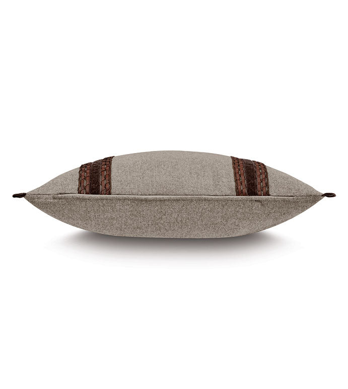 The CRISTOBAL FAUX LEATHER pillow by Eastern Accents is a grey rectangular accent with brown woven leather stripes and braided end accents, shown from the side against a white background.