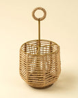 The Indaba Woven Cutlery Holder, crafted from sustainable rattan and metal, features a circular handle and is displayed against a light beige background.