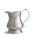 The Faire Vintage Pitcher with Deer features a silver Italian pewter design, ornate handle, wide spout, engraved deer and trees on a rounded body, and stands on a flared base with floral details.