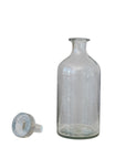 The Creative Co-op Decanter 20oz, a clear glass vessel with a narrow neck, stands upright beside its matching stopper on a plain white background—an elegant barware piece for the modern host.