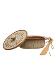 A rustic Brie Baker by Creative Co-op, topped with a speckled beige lid labeled “Brie Baker,” is shown partially open to reveal the inside and comes with a bamboo spreader inspired by farmhouse knives, tied neatly with string.