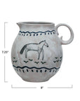The Creative Co-op Horse Pitcher is a 7.25" tall, 8" wide round ceramic pitcher with a handle, featuring hand-painted horse print, blue wavy lines, and green accents for a charming farmhouse look.