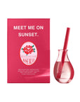 A red box labeled "MEET ME ON SUNSET" and "ROSE BLVD" sits beside a small glass vase with pink liquid, a pink straw, and the brand name "Faire," evoking the mood-boosting floral Boost Reed Diffuser home fragrance.