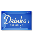 A vibrant blue neon sign against a dark background at a bungalow in Scottsdale, Arizona, displaying the phrase "Drinks are on me" in white cursive lettering on a Ben's Garden Tray 5.5" x 8.5".