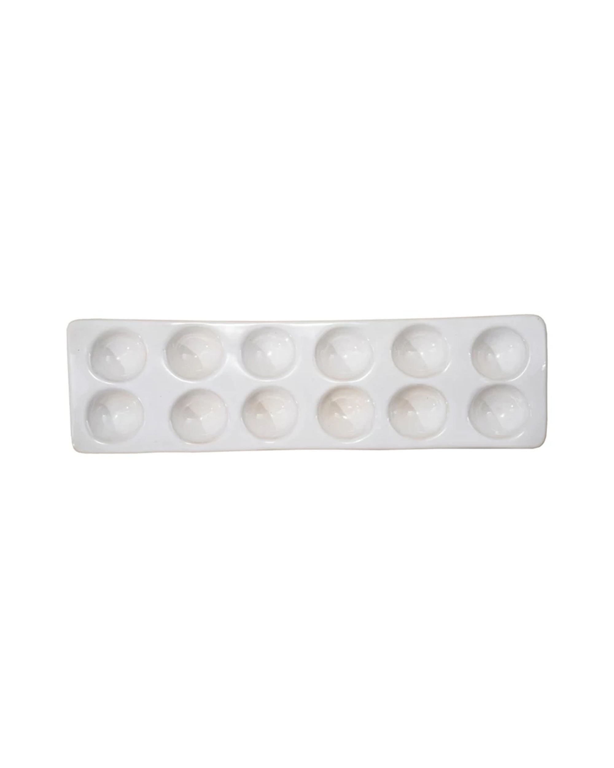 The Bloomingville Stoneware Egg Holder is rectangular, white, and features ten round wells in two rows of five, shown from above on a white background.