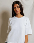 A woman with long dark hair models the Perfectwhitetee French Terry SS Loose Sweatshirt and blue jeans against a neutral backdrop, looking at the camera with a relaxed expression that highlights the sweatshirt’s loose fit.