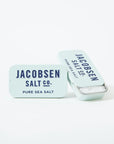 Two small Kosher Sea Salt slide Tins from Faire are shown on a white background—one open to display the salt inside. The tins are light blue with dark blue text, creating a clean, modern look.