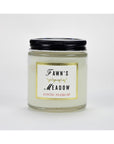 A glass jar Austin Press Travel Candle by Faire features a black lid, “Fawn’s Meadow” in bold, and “Austin Press SF” in red. The jar contains pale botanical waxes for an all-natural candle experience.