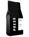 A 5lb black coffee bag from Jeff's Antiques, labeled "PRESS" and "FOUR CORNERS blend," features milk chocolate notes, big body, and low acidity. This blend combines Latin American and Sumatran beans for a rich taste.
