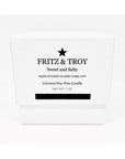 A white box with black text reads: "Fritz & Troy Sweet & Salty Candle. Hand poured in NYC. Coconut/soy wax candle with an oceanic accord. Net Wt. 7 oz." A black star sits above the brand name.