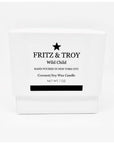 A white candle box labeled "Fritz & Troy Wild Child" holds a hand-poured coconut/soy wax candle made in NYC, with mandarin, jasmine, and amber notes. "NET WT. 7 OZ" is printed boldly on the front.