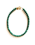 The Galleria Necklace by Faire is a 17-inch piece with green round malachite beads and gold-plated findings, displayed in a circle on a white background.