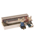 Two small Maileg Mice from Maileg, dressed in clothes, sit by an open matchbox-style bed with pillow and blanket. The box features vintage designs, making it a charming addition to your mouse family collection.