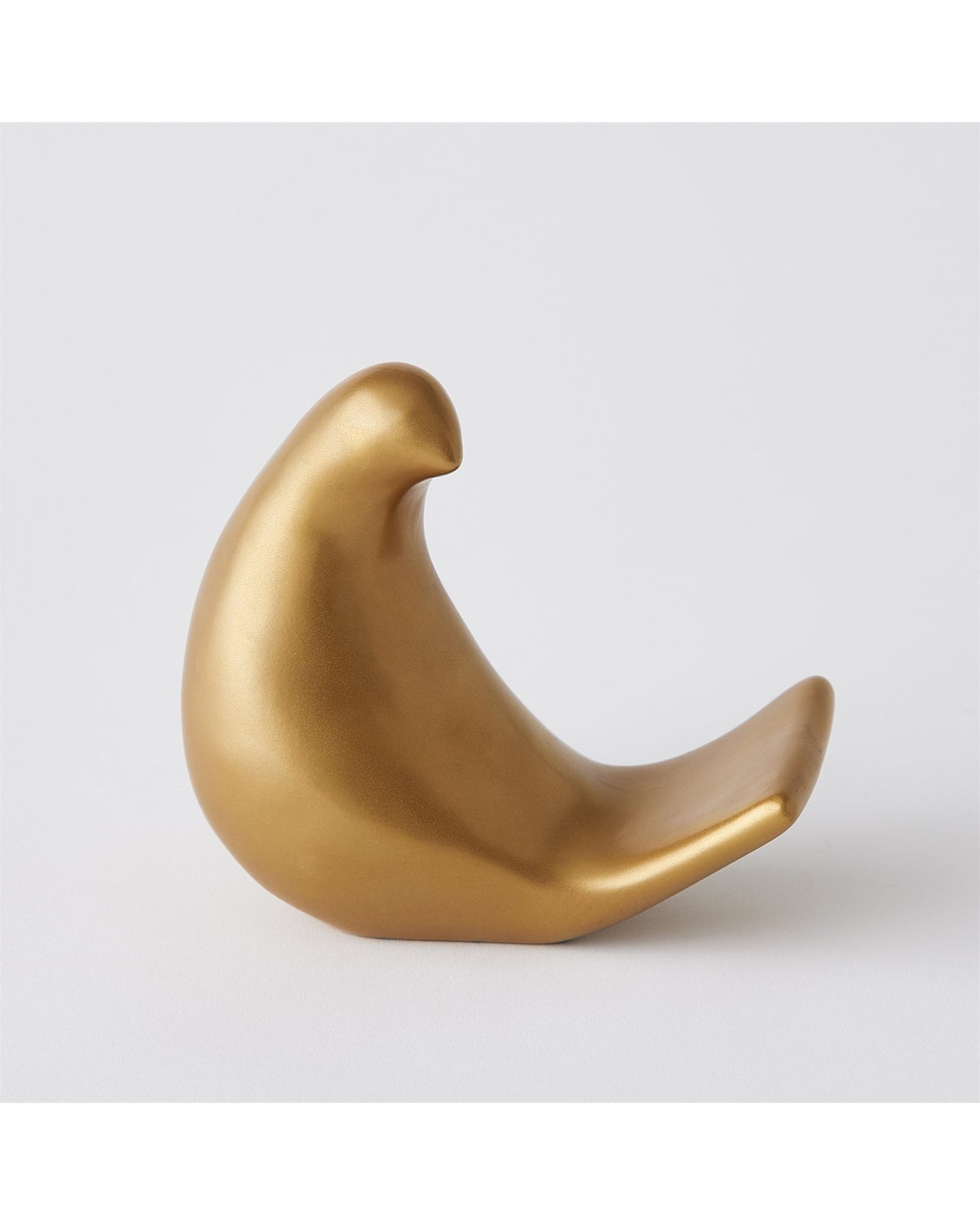 A smooth, abstract gold sculpture in Matte Antique Gold from Global Views, Les Animaux Moineau Gold features a minimalist bird with a rounded body and curved beak, shown on a plain white background.