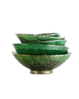 A set of four green, hand-crafted Tamegroute Bowls by Blue Ocean Traders with wavy edges creates a striking decorative accent against a white background.