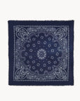 The Hachiko Scarf by BCS Group is a navy blue accessory with a white paisley and floral design arranged symmetrically, and fringed edges that evoke the look of a classic printed cashmere scarf.