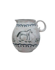 The Creative Co-op DF9888 Horse Pitcher is a hand-painted farmhouse-style centerpiece, featuring a handle and simple horse and grass design bordered by wavy lines on a light background.