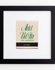 Framed matchbook from Hotel Bel-Air in Los Angeles. The matchbook is cream-colored with "Hotel Bel-Air" written in green script and "Los Angeles" below in smaller print. The Art Square Blk Frame, made of clear acrylic, contrasts elegantly with the white background by Match South.