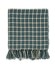 The Indaba Houndstooth Throw in Teal is a soft Indian cotton blanket with a blue and white pattern and textured fringe tassels along the bottom edge, shown folded on a white background.
