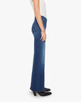 Mother’s The Hustler Roller Sneak blue jeans styled with a white top and black boots, shown in profile.