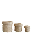 Three Faire Round Lidded Jute Baskets in natural color are arranged from largest to smallest on a white background.
