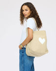 KR Imperfect Heart Hobo Tote by Kerri Rosenthal, carried by woman in casual white shirt and jeans, over-the-shoulder style.