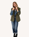 Army green blazer by Kerri Rosenthal styled with denim shirt, cuffed jeans, and black boots for a casual look.