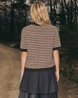 Sea New York DECLAN short sleeve polo sweater and pleated skirt in a relaxed, outdoor setting on a dirt road.