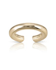 The Lisa Ear Cuff by Faire features a shiny, 10K gold open-ended design with a smooth, thick band for mid-ear cartilage, shown on a white background with a subtle reflection.